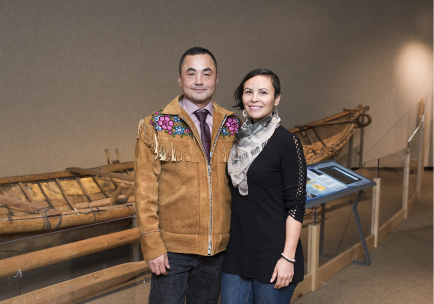 The two founders of the company standing side-by-side in front of a traditional aboriginal river boat
